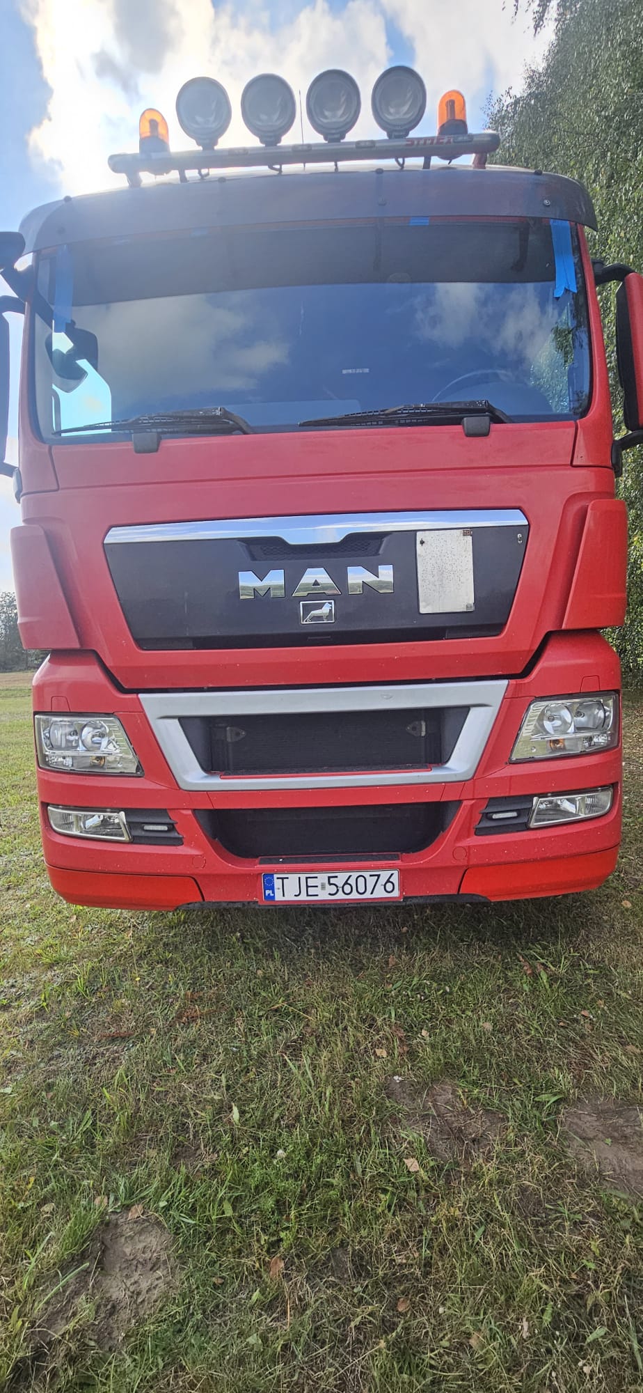 Czerwona ciężarówka MAN z nową szybą czołową po mobilnym montażu
